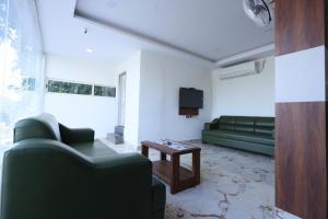 een woonkamer met een groene bank en een tafel bij NO 7 Grandeur Hotel in Bangalore