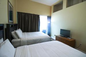 a hotel room with two beds and a television at Castle Ph2 Balcony Oceanfront Condo, Beach Access, Pool, Tennis, Free Parking in Miami Beach