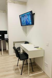 Zimmer mit einem Schreibtisch und einem TV an der Wand in der Unterkunft Center Lviv Avenue 23 in Lwiw