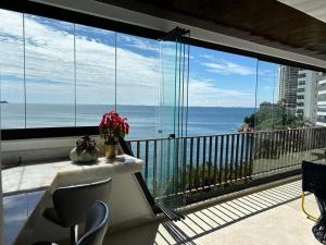 a room with a balcony with a view of the ocean at Condomínio Costa Esmeralda in Guarujá