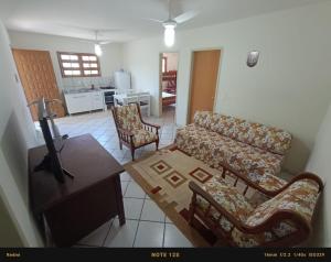 ein Wohnzimmer mit einem Sofa, Stühlen und einem Tisch in der Unterkunft Casa PRAIA DOS INGLESES in Florianópolis