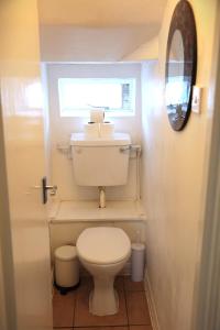 a small bathroom with a toilet and a window at Camden Studio in London