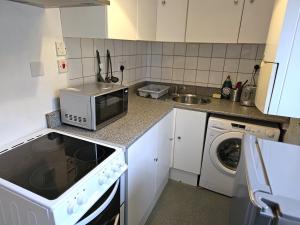 a small kitchen with a microwave and a sink at Camden Studio in London
