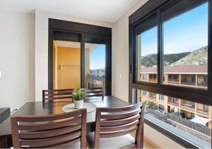 una sala da pranzo con tavolo, sedie e finestre di Be HAPPY 77 ad Arona