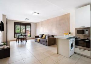 una cucina e un soggiorno con un divano e un tavolo di Be HAPPY 77 ad Arona