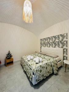 a bedroom with a bed and a chandelier at Al Corso 146 in Torre del Greco