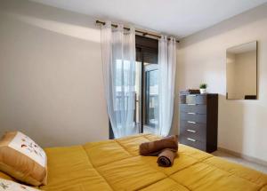 una camera da letto con un grande letto giallo e una finestra di Be HAPPY 77 ad Arona Altre 15 foto