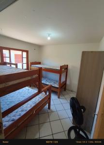 a room with two bunk beds and a table at Casa PRAIA DOS INGLESES in Florianópolis