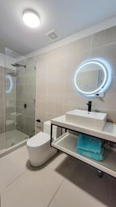 a bathroom with a toilet and a sink and a mirror at Anika Boutique Suites in Coco
