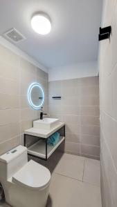 La salle de bains est pourvue de toilettes, d'un lavabo et d'un miroir. dans l'établissement Anika Boutique Suites, à Coco