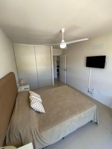 1 dormitorio con 1 cama y ventilador de techo en Depto - Edificio OPERA 1 - Solo Familiar en Villa Carlos Paz