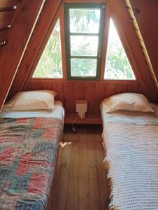 2 camas en una habitación con 2 ventanas en Casa Playa Puertecillo, en Puertecillo