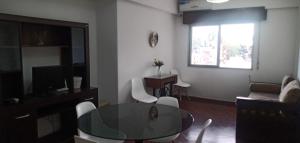 sala de estar con mesa de cristal y sofá en Departamento temporario consultar estacionamiento en Salta