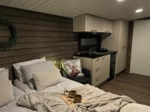 a bedroom with a bed and a kitchen in it at Tunnelmallinen ja ihana mökki in Rovaniemi