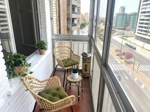 balcón con 2 sillas, mesa y ventanas en Acogedor apartamento a 5 min del Ave, en Zaragoza