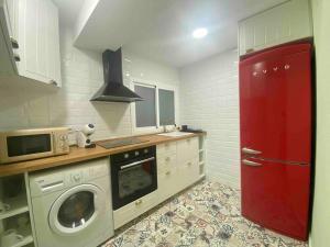 cocina con puerta roja y lavadora en Acogedor apartamento a 5 min del Ave, en Zaragoza