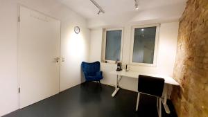 Zimmer mit einem Schreibtisch, 2 Stühlen und einer Uhr in der Unterkunft 1-Zimmer-Wohnung im Loft in Mannheim