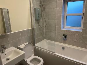 a bathroom with a white toilet and a sink at Beautiful Family Home in Mickleover