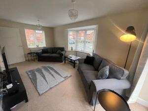 a living room with a couch and a table at Beautiful Family Home in Mickleover