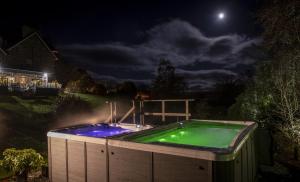a hot tub in a backyard at night at Duisdale House Hotel in Isleornsay
