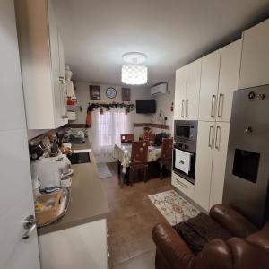 a kitchen with white cabinets and a dining room at Shared accommodation a room with a view of the garden in Seville