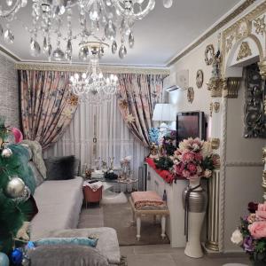 a living room with a chandelier and a couch at Shared accommodation a room with a view of the garden in Seville