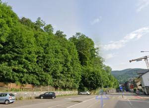 a street with cars parked on a road with trees at Butthouse Apartments in Trimbach