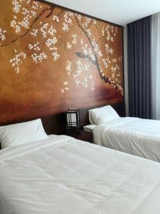 um quarto com duas camas e um quadro na parede em Fuwa Fuwa Home - Wyndham Lynn Times Thanh Thủy- Khu nghỉ dưỡng Khoáng nóng em Phú Thọ