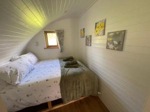 Dormitorio pequeño con cama en el ático en Wimbish Hall Cabins en Wimbish