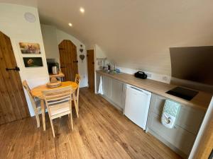 cocina con mesa, mesa pequeña y sillas en Wimbish Hall Cabins en Wimbish