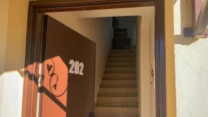 a stairway with a door with the number on it at Zahara Sol Villas y Apartamentos by QHotels in Zahara de los Atunes