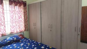 ein Schlafzimmer mit einem Bett und einigen Schränken und einem Fenster in der Unterkunft Stayzilla Santhoshini Homes 2 BHK in Vellore