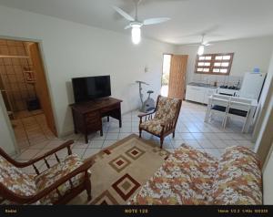 sala de estar con sofá, sillas y TV en Casa PRAIA DOS INGLESES en Florianópolis