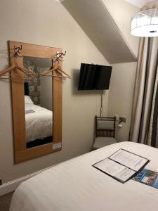 a hotel room with a bed and a mirror at Ravenswood Guest House in Stirling