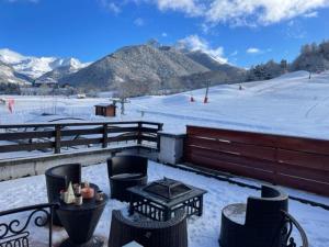 a patio with a table and chairs in the snow at Le Logis de Bamby in Ancelle