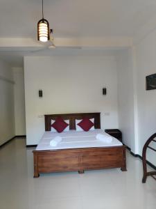 1 dormitorio con 1 cama grande con almohadas rojas en Leen Tangalle en Tangalle