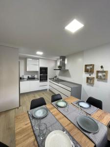 une salle à manger avec une table et une cuisine dans l'établissement Duplex Casa da barbeira, à Cangas