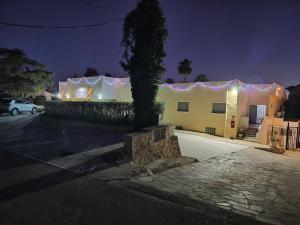 a building with a tree in a parking lot at night at Aparthotel Carrio Sol - Monty´s in Calpe