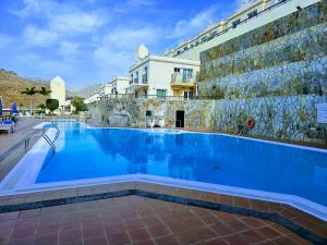 een groot zwembad naast een gebouw bij Residence Puerto Rico in Puerto Rico de Gran Canaria