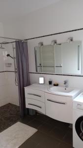 Baño blanco con lavabo y espejo en gite du bois doré, en Les Vignères