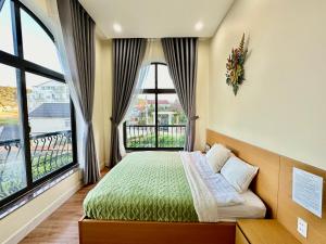 - une chambre avec un lit et une grande fenêtre dans l'établissement Adalia Villa & Hotel Đà Lạt, à Đà Lạt