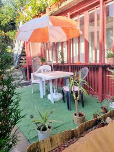 a table and chairs and an umbrella on a patio at Cosy Studio-House with Terrace in Târgu-Mureş