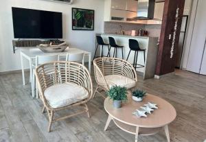 a living room with two chairs and a table at KASA Brisa Marina - 1 bed 1 bath for 2 OCEAN VIEW BALCONY BEACHFRONT CONDO POOL in San Juan