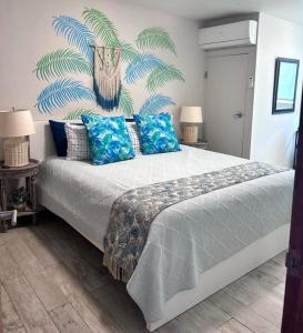 um quarto com uma cama grande e almofadas azuis em KASA Brisa Marina - 1 bed 1 bath for 2 OCEAN VIEW BALCONY BEACHFRONT CONDO POOL em San Juan