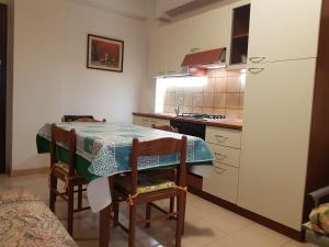 a small kitchen with a table and a refrigerator at SANT'ALESSIO_BAY in Santa Margherita-Sant'Alessio Siculo