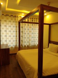 Luxury 2BHK Apartment Near Candolim في Nerul: غرفة نوم مع سرير مظلة ونافذة