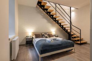a bedroom with a bed and a staircase at Eclectic and design duplex in Prague in Prague