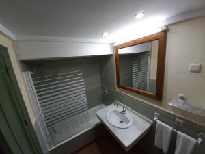 a bathroom with a sink and a mirror and towels at Plaza Andalucía Edificio Dornajo 2-4 pax in Monachil