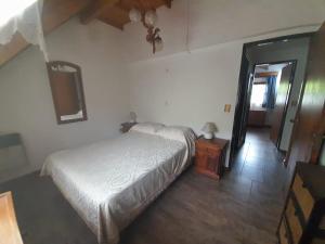 a bedroom with a white bed and a wooden floor at La Casa de la Isla in San Martín de los Andes