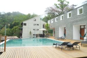 une maison avec une piscine sur une terrasse en bois dans l'établissement Pousada Golf Village, à Itaipava